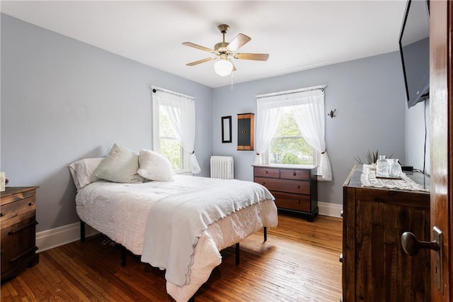 110 Lansdale St, Rochester, NY 14620 - bedroom with radiator, multiple windows, baseboards, and wood finished floors