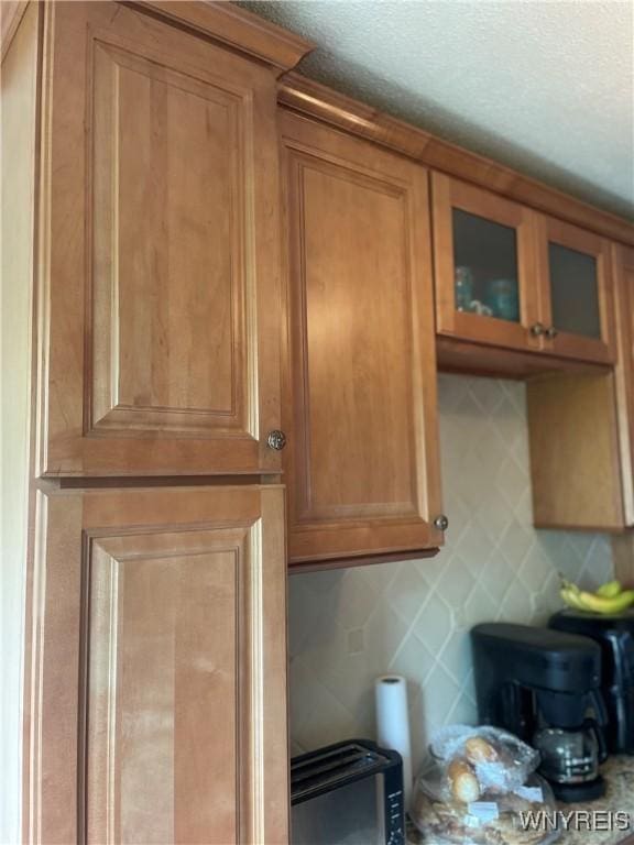 151 Buffalo Ave Unit 404, Niagara Falls, NY 14303 - kitchen view of brown cabinets, glass insert cabinets, and decorative backsplash