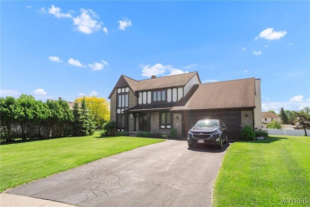 24 Bluejay Cir, Lancaster, NY 14086 - tudor home with an attached garage, asphalt driveway, and brick siding