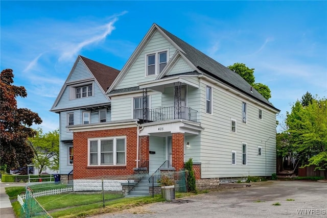 405 W Ferry St, Buffalo, NY 14213 - view of front of house featuring a balcony, a fenced front yard, and brick siding