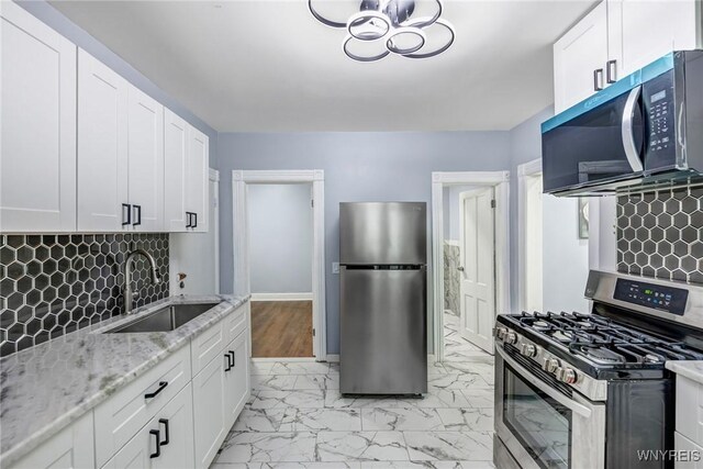 405 W Ferry St, Buffalo, NY 14213 - kitchen with appliances with stainless steel finishes, a sink, light marble finish flooring, white cabinetry, and light stone countertops