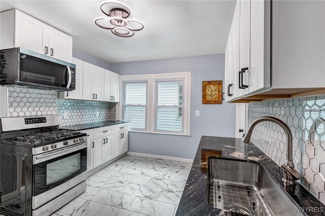 405 W Ferry St, Buffalo, NY 14213 - kitchen with stainless steel appliances, a sink, light marble finish floors, decorative backsplash, and dark stone countertops