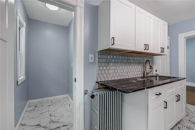 405 W Ferry St, Buffalo, NY 14213 - kitchen featuring a sink, radiator heating unit, marble finish floors, dark stone countertops, and white cabinets