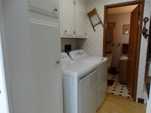 136 Platt St, Erwin, NY 14870 - laundry room with cabinet space, washing machine and clothes dryer, light wood-style flooring, and wallpapered walls