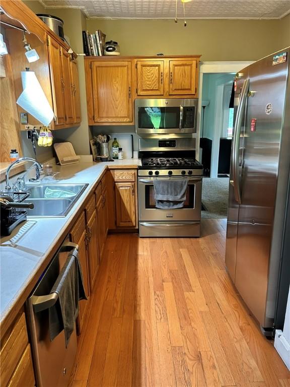 2287 State Route 352, Big Flats, NY 14903 - kitchen with appliances with stainless steel finishes, a sink, light wood finished floors, light countertops, and brown cabinets