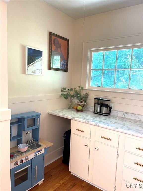 626 Roberts Ave, Syracuse, NY 13207 - kitchen featuring wood finished floors, white cabinetry, and baseboards