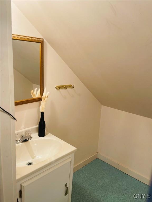 626 Roberts Ave, Syracuse, NY 13207 - bathroom with lofted ceiling, vanity, and baseboards
