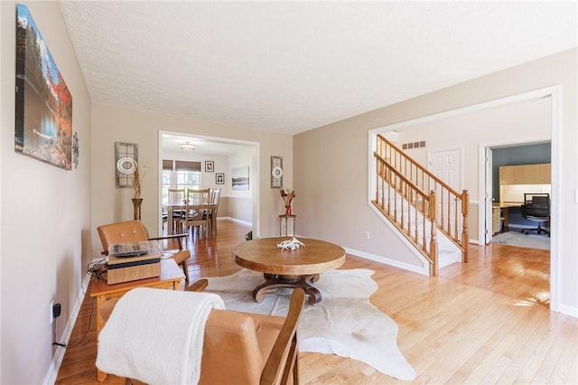 56 Edenfield Rd, Penfield, NY 14526 - living area with stairs, light wood-type flooring, and baseboards