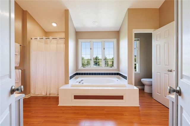 56 Edenfield Rd, Penfield, NY 14526 - bathroom featuring toilet, a bath, and wood finished floors