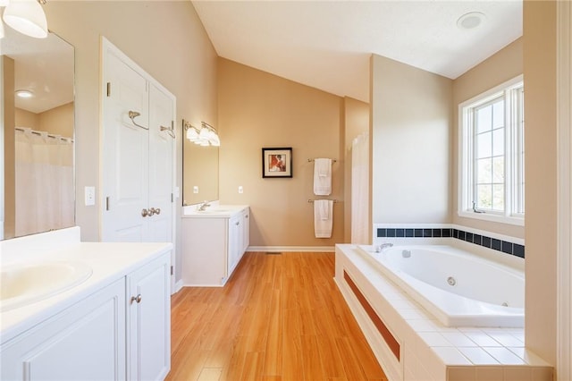 56 Edenfield Rd, Penfield, NY 14526 - full bathroom with wood finished floors, two vanities, a whirlpool tub, and baseboards