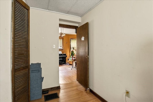 262 Pearl St, Rochester, NY 14607 - hall featuring light wood-type flooring, a drop ceiling, baseboards, and a chandelier