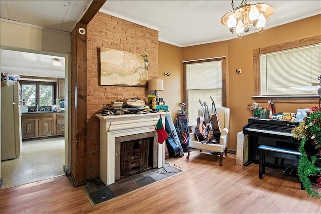 262 Pearl St, Rochester, NY 14607 - living area with wood finished floors, a chandelier, a large fireplace, and crown molding