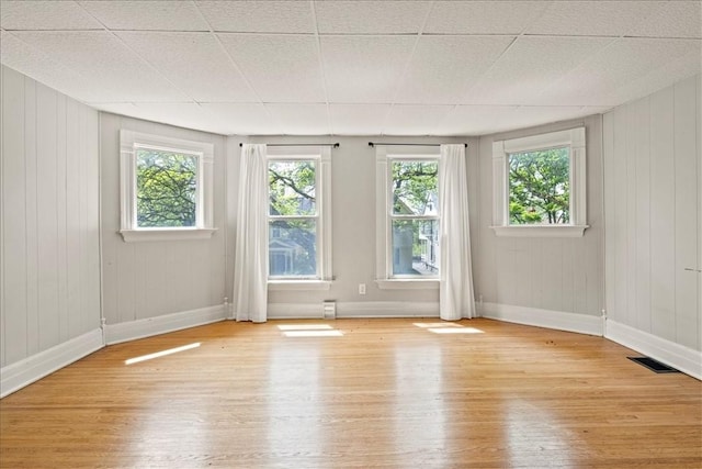 262 Pearl St, Rochester, NY 14607 - empty room with hardwood / wood-style flooring, healthy amount of natural light, baseboards, and wooden walls