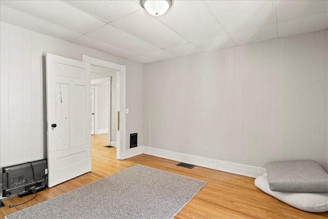 262 Pearl St, Rochester, NY 14607 - empty room featuring wood finished floors, baseboards, a drop ceiling, and wooden walls