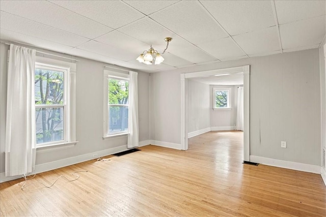 262 Pearl St, Rochester, NY 14607 - unfurnished room with baseboards, light wood-type flooring, a chandelier, and a paneled ceiling