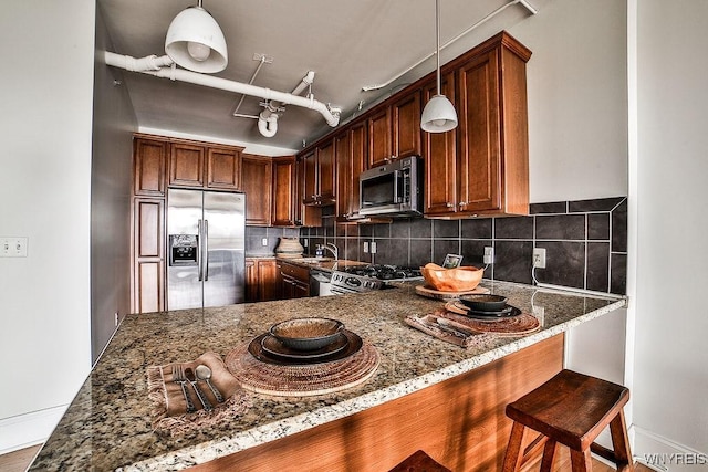 132 Lakefront Blvd Unit 204, Buffalo, NY 14202 - kitchen featuring stainless steel appliances, stone counters, backsplash, pendant lighting, and baseboards