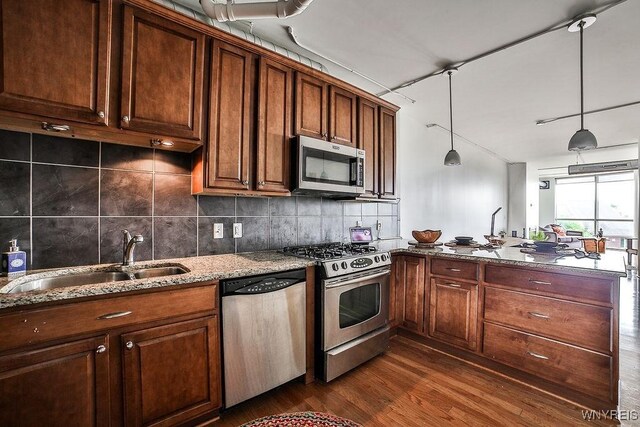 132 Lakefront Blvd Unit 204, Buffalo, NY 14202 - kitchen with appliances with stainless steel finishes, a sink, a peninsula, dark wood-style flooring, and stone countertops