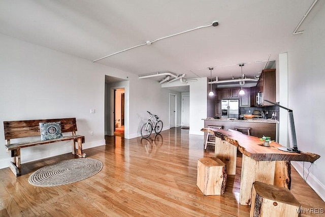 132 Lakefront Blvd Unit 204, Buffalo, NY 14202 - kitchen featuring appliances with stainless steel finishes, light wood finished floors, dark brown cabinetry, and pendant lighting