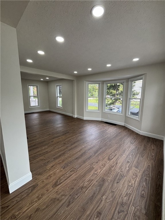 3758 Lake Rd N, Clarkson, NY 14420 - unfurnished living room featuring a textured ceiling, baseboards, dark wood-style floors, and recessed lighting