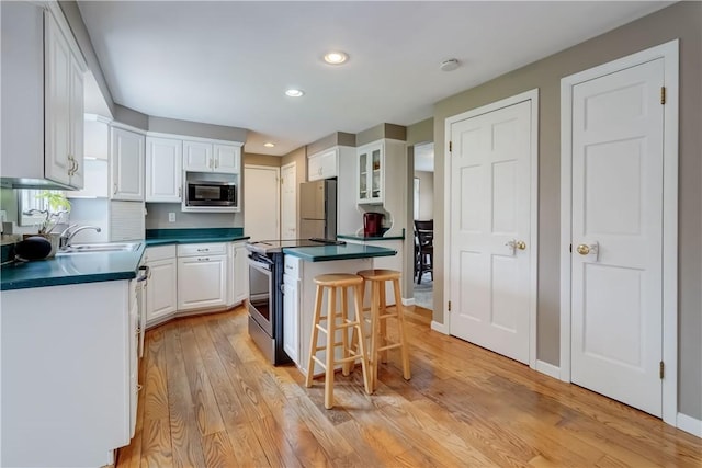 16 Canterbury Trl, Penfield, NY 14450 - kitchen with stainless steel appliances, a sink, dark countertops, white cabinetry, and recessed lighting