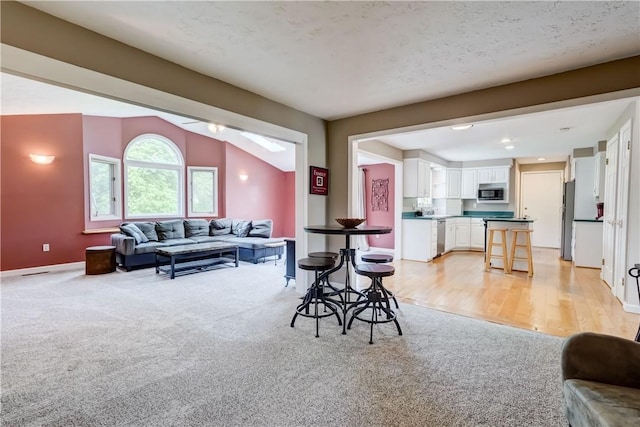 16 Canterbury Trl, Penfield, NY 14450 - living room featuring light colored carpet, lofted ceiling, baseboards, and a ceiling fan