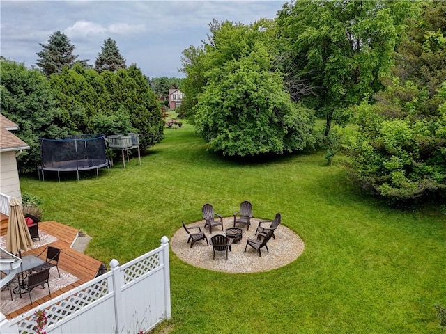 16 Canterbury Trl, Penfield, NY 14450 - view of grassy yard featuring a fire pit, a trampoline, and a deck