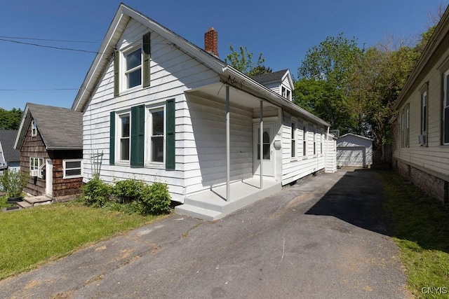 410 John St, Syracuse, NY 13208 - view of front of house with a chimney, an outbuilding, a detached garage, and a front yard