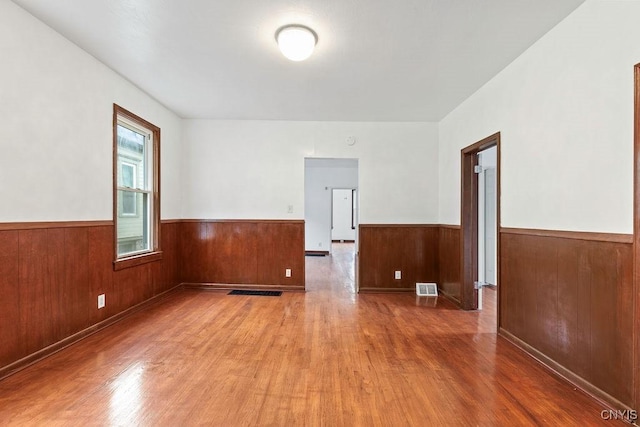 410 John St, Syracuse, NY 13208 - unfurnished room with wood finished floors, a wainscoted wall, and wood walls