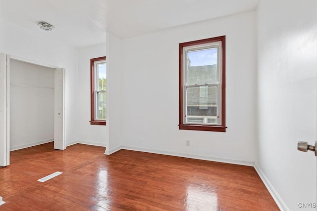 410 John St, Syracuse, NY 13208 - unfurnished bedroom featuring multiple windows, wood finished floors, and baseboards