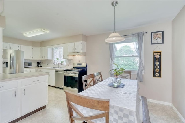 39 Ingram Dr, Gates, NY 14624 - kitchen with stainless steel appliances, under cabinet range hood, light countertops, backsplash, and a sink