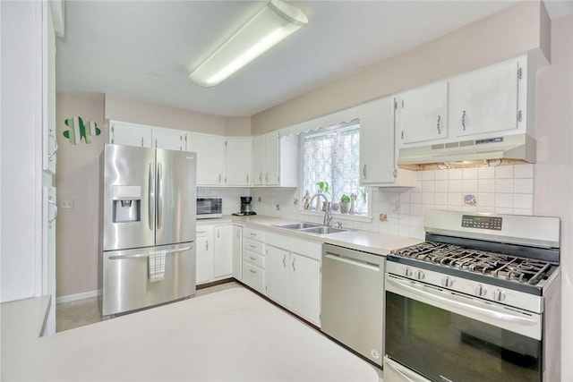 39 Ingram Dr, Gates, NY 14624 - kitchen with stainless steel appliances, under cabinet range hood, a sink, decorative backsplash, and white cabinetry