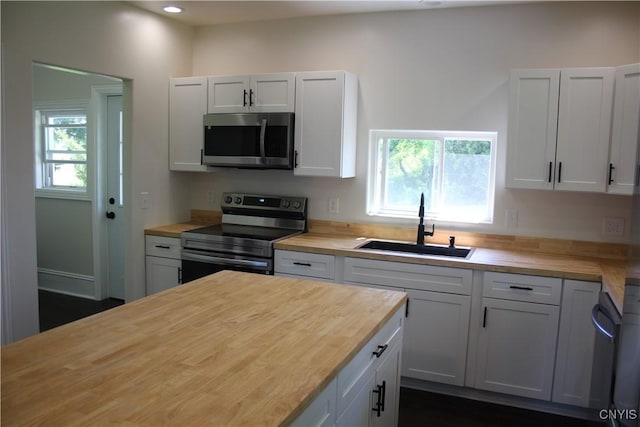8766 N Main St, Le Ray, NY 13637 - kitchen with appliances with stainless steel finishes, wooden counters, a sink, white cabinets, and recessed lighting