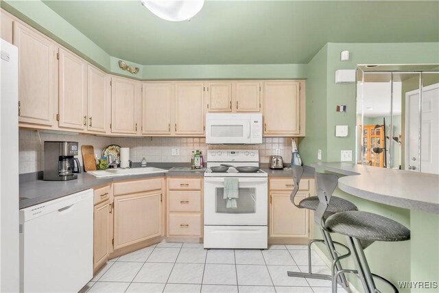 950 Hopkins Rd Unit B, Amherst, NY 14221 - kitchen with white appliances, a sink, decorative backsplash, light tile patterned floors, and a peninsula