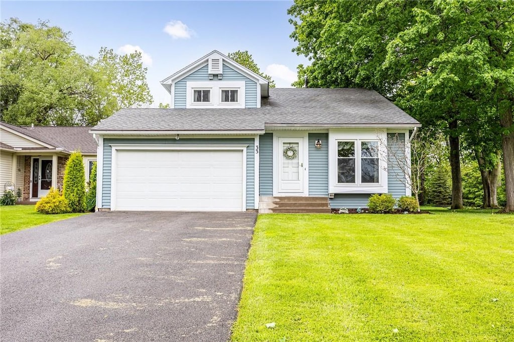 33 Westover Dr, Webster, NY 14580 - view of front of home with driveway, a garage, a front lawn, and a shingled roof