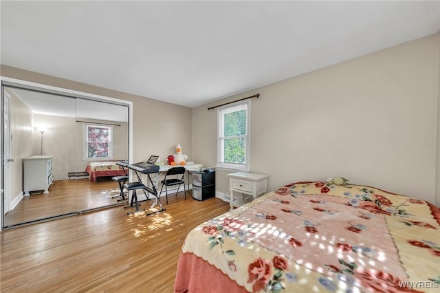 8918 Hurlburt Ln, Clarence, NY 14031 - bedroom featuring light wood-style floors, a baseboard radiator, and baseboards