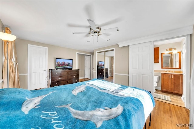 8918 Hurlburt Ln, Clarence, NY 14031 - bedroom with light wood finished floors, a sink, two closets, ensuite bath, and ceiling fan
