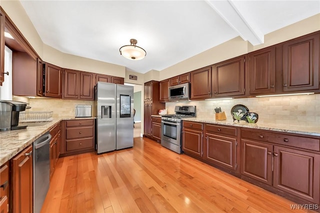 8918 Hurlburt Ln, Clarence, NY 14031 - kitchen featuring stainless steel appliances, tasteful backsplash, light wood-style flooring, light stone countertops, and beam ceiling