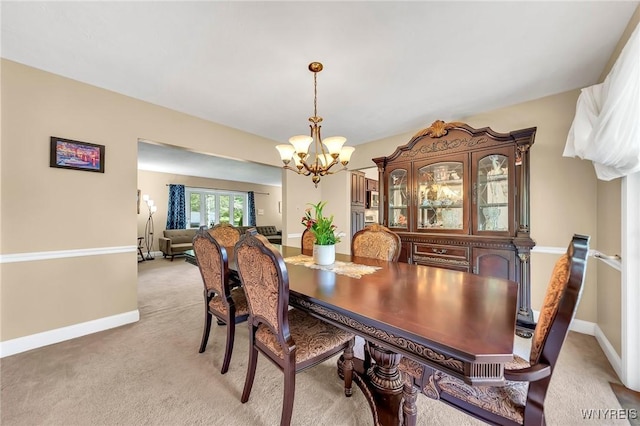 8918 Hurlburt Ln, Clarence, NY 14031 - dining area featuring a chandelier, light carpet, and baseboards