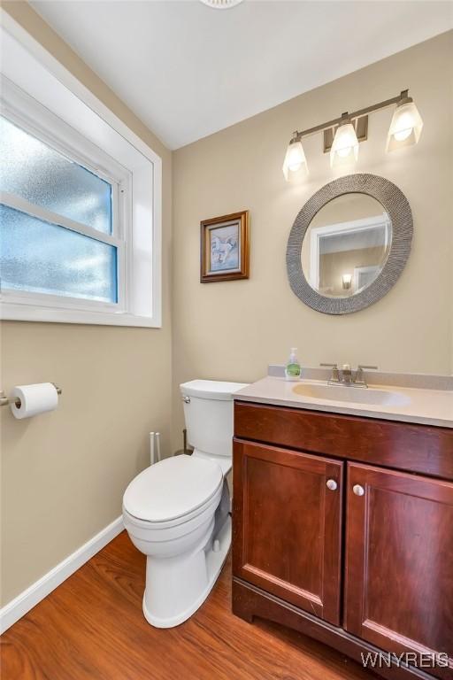 8918 Hurlburt Ln, Clarence, NY 14031 - bathroom featuring vanity, wood finished floors, toilet, and baseboards