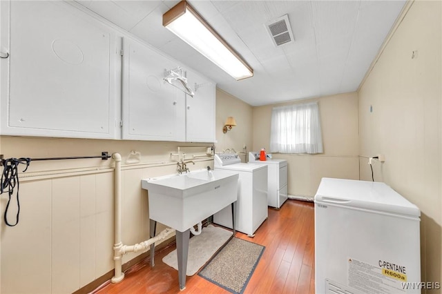 8918 Hurlburt Ln, Clarence, NY 14031 - washroom with cabinet space, independent washer and dryer, and light wood finished floors