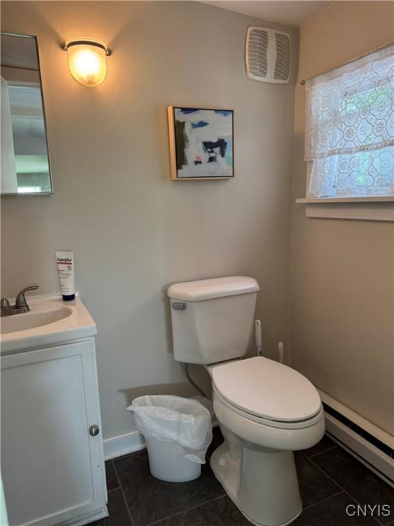 22 Hamilton St, Hamilton, NY 13346 - half bathroom with a baseboard radiator, toilet, tile patterned floors, and vanity