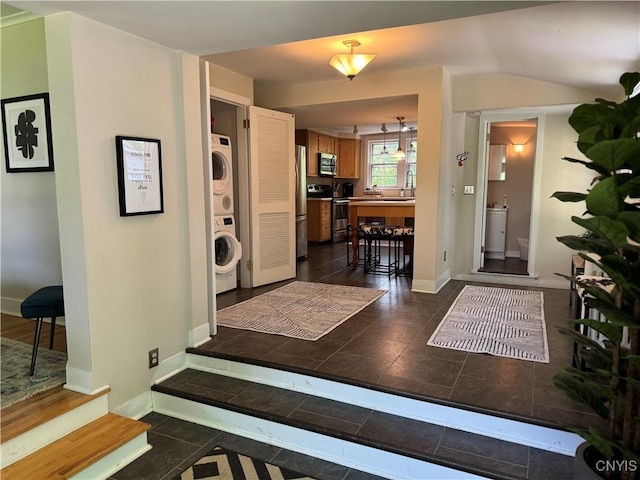 22 Hamilton St, Hamilton, NY 13346 - entryway featuring stacked washer and clothes dryer, baseboards, and dark tile patterned floors