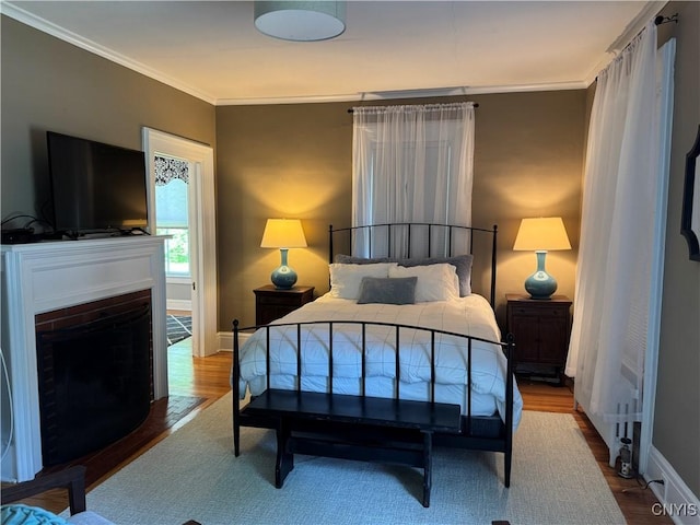 22 Hamilton St, Hamilton, NY 13346 - bedroom featuring ornamental molding, wood finished floors, a fireplace with flush hearth, and baseboards
