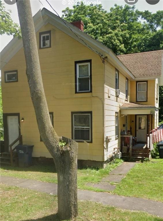 190 Canal St, Lyons, NY 14489 - view of front of house featuring covered porch, a front yard, a chimney, and a shingled roof