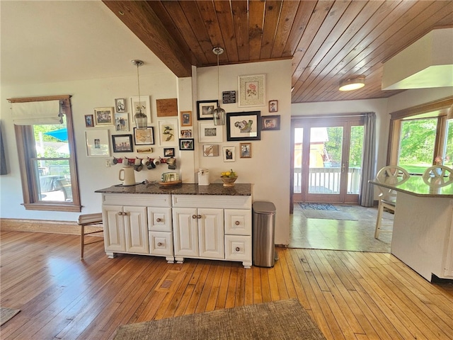 6207 Knickerbocker Rd, Ontario, NY 14519 - kitchen featuring wood-type flooring, wood ceiling, white cabinets, dark stone counters, and decorative light fixtures