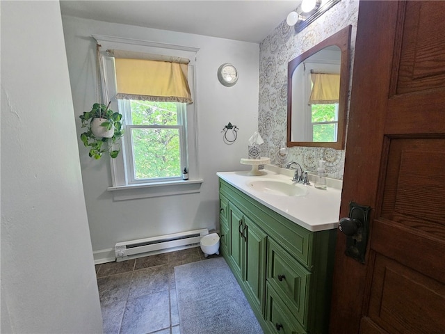 6207 Knickerbocker Rd, Ontario, NY 14519 - bathroom featuring a baseboard heating unit, vanity, baseboards, wallpapered walls, and stone finish floors