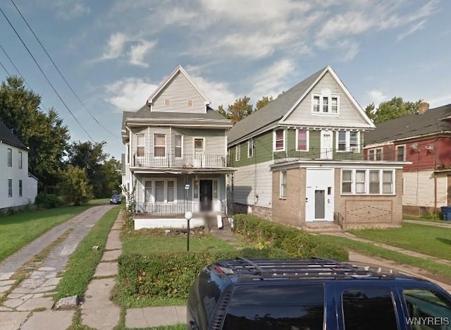70 Rickert Ave, Buffalo, NY 14211 - view of front of house featuring a balcony, covered porch, a front lawn, and brick siding