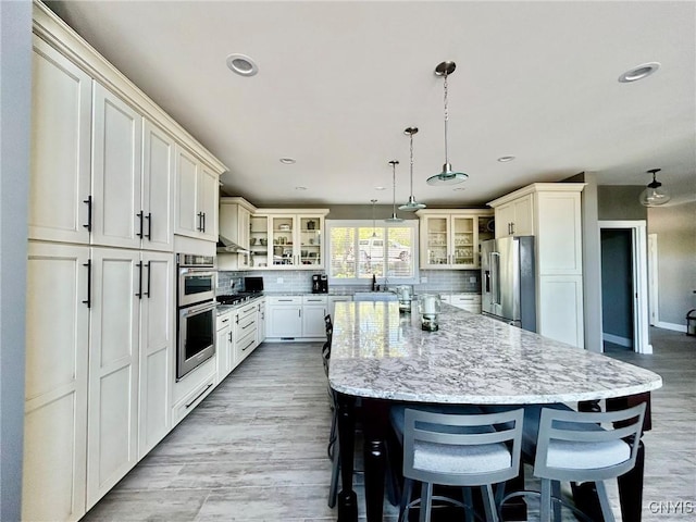 2 Perch Bay Rd, Morristown, NY 13669 - kitchen with appliances with stainless steel finishes, a kitchen island, glass insert cabinets, light stone counters, and recessed lighting