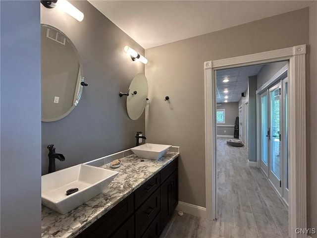 2 Perch Bay Rd, Morristown, NY 13669 - full bathroom featuring double vanity, wood finished floors, and baseboards