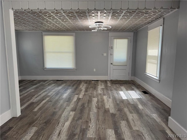 354 Schenck St, North Tonawanda, NY 14120 - unfurnished dining area with a chandelier, baseboards, wood finished floors, and an ornate ceiling